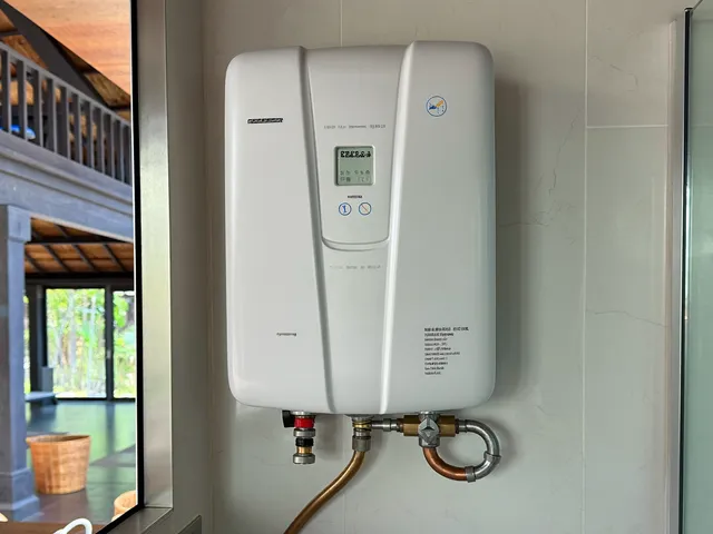 Compact instant tankless water heater on a bathroom wall
