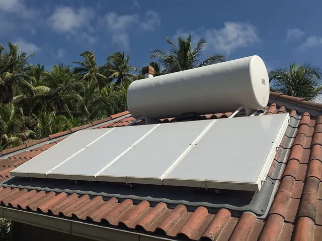 Solar water heater panels and tank on a Bali villa roof